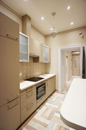 Contemporary small kitchen with beige cabinets and patterned flooring.