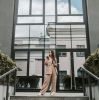 Confident businesswoman in brown suit standing outside modern building.
